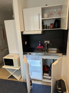 una pequeña cocina con armarios blancos y fregadero en Business Appartement Mainz Duo, en Mainz
