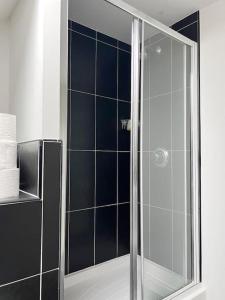 a shower with a glass door in a bathroom at Duxford House by Blue Skies Stays in Middlesbrough