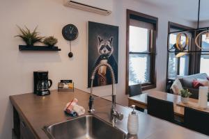 a kitchen with a sink and a dog picture on the wall at Lake Resort Suite: Views & Amenities in Lac-Superieur