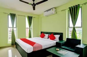 PānchuriaにあるGoroomgo Green Oasis Inn Kolkataのベッドルーム1室(赤い枕のベッド1台付)