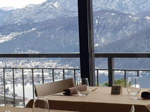 a table with wine glasses and a view of a mountain at Hotel Ristorante Stampa in Lavena Ponte Tresa