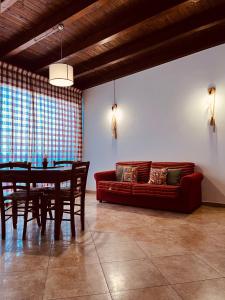 - un salon avec une table et un canapé rouge dans l'établissement Sicilia Vacation, à Trapani