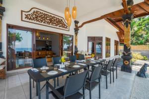 a dining room with a long table and chairs at Bali Taoka Beach Villa in Singaraja