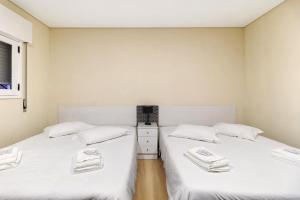 2 camas en una habitación con sábanas blancas en Apartamento Vi-ana, en Viana do Castelo