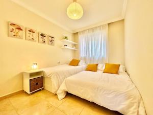 two beds in a small room with a window at Apartamento Vista Faro in Poris de Abona +42 photos