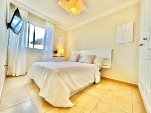 ein Schlafzimmer mit einem weißen Bett und einem Fenster in der Unterkunft Apartamento Vista Faro in Poris de Abona