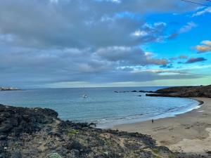 a beach with a boat in the water at Apartamento Vista Faro in Poris de Abona