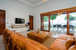 a living room with a couch and a coffee table at Bali Taoka Beach Villa in Singaraja
