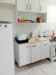 eine Küche mit weißen Schränken und einer Arbeitsplatte in der Unterkunft Apê da Mel - Recife PE in Recife