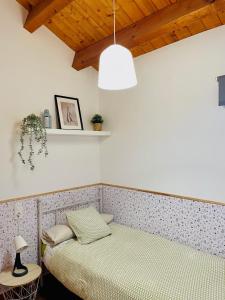 um quarto com 2 camas individuais e um candeeiro em CASA DE LA BODEGA em L'Espluga de Francolí