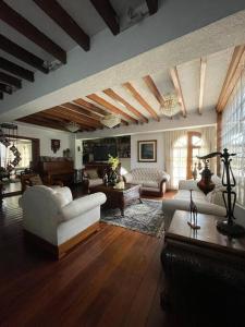 uma grande sala de estar com sofás brancos e uma mesa em Casa hermosa, amplia y elegante em Quito