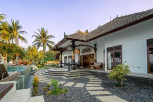 une villa avec une piscine et une maison dans l'établissement Bali Taoka Beach Villa, à Singaraja