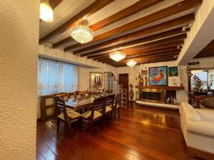 uma sala de jantar e sala de estar com mesa e cadeiras em Casa hermosa, amplia y elegante em Quito