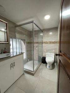 uma casa de banho com um chuveiro e um WC. em Casa hermosa, amplia y elegante em Quito