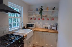 a kitchen with a sink and a stove at Stunning period cottage in Wrington