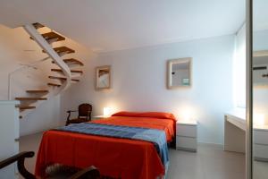 a bedroom with a bed and a staircase at AT049 Els Pins, primera línea de la playa con piscina y barbacoa in Torredembarra +40 photos