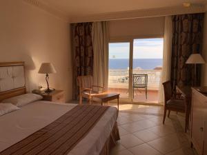 Continental Plaza Beach Resort في شرم الشيخ: غرفة نوم مع سرير وإطلالة على المحيط