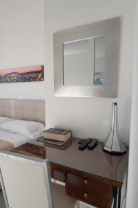 sypialnia z biurkiem, łóżkiem i lustrem w obiekcie Napolidays Toledo Apartment By Dimorra w mieście Neapol