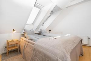 two beds in a room with two windows at Centralt Byliv - 2 Soveværelser med plads til 6 in Aarhus