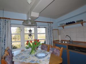 a kitchen with a table with a vase of flowers on it at Ferienhaus Zur Alten Post 1 in Ockholm