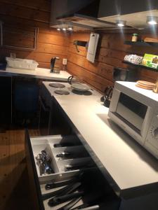 uma cozinha com um fogão e um micro-ondas em A cosy cottage in Norrtälje em Norrtälje