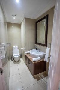 uma casa de banho com um lavatório e um WC em Stay at The Point - Leopards Lair em Durban