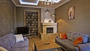 a living room with two couches and a fireplace at 7 Rooms Hotel in Tserovani