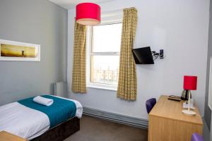 1 dormitorio con cama y ventana en The Grand Atlantic Hotel, en Weston-super-Mare