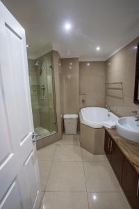 uma casa de banho com uma banheira, um WC e um lavatório. em Stay at The Point - Leopards Lair em Durban