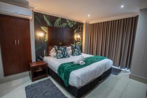 um quarto com uma cama grande e um cobertor verde em Stay at The Point - Leopards Lair em Durban