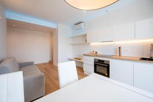 een keuken en een woonkamer met witte kasten en een bank bij Casa Giorgia in Milaan