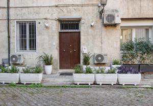 una fila de macetas blancas de plantas delante de una puerta en Piazza Navona - Roma Centro Storico, en Roma
