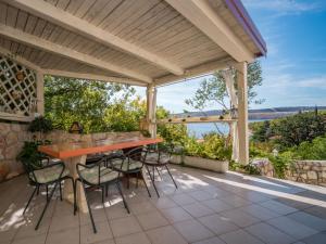 an outdoor patio with a wooden table and chairs at Apartment Vlasta-1 by Interhome in Jadranovo