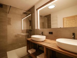 a bathroom with two sinks and a mirror and a tub at Holiday Home bergGLÜCK by Interhome in Spiss