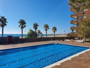 a swimming pool with the beach in the background at AT049 Els Pins, primera línea de la playa con piscina y barbacoa in Torredembarra