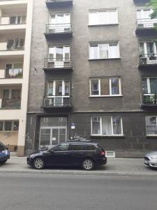 a black car parked in front of a building at Studio near Old Town in Krakow +1 photo