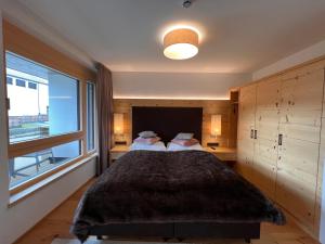 a bedroom with a large bed with a large window at Apartment Lakeside Luxury Apartments by Interhome in Zell am See