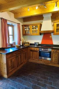 uma cozinha com armários de madeira e um forno com placa de fogão em Holiday Home st martin chalets-1 by Interhome em Sankt Martin
