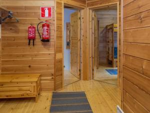 Habitación con paredes de madera y extintor de incendios en la pared. en Holiday Home Elnan tupa by Interhome en Ylläs