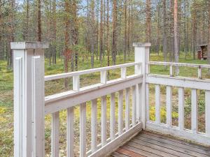 valla blanca con terraza de madera en el bosque en Holiday Home Elnan tupa by Interhome en Ylläs