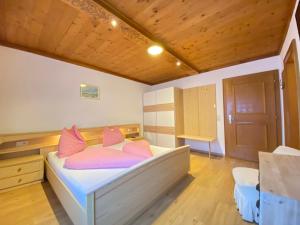 a bedroom with a bed with pink pillows on it at Holiday Home IN8 - max- 7 Personen by Interhome in Saalbach-Hinterglemm