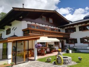 een huis met een patio en een tuin bij Holiday Home IN8 - max- 7 Personen by Interhome in Saalbach Hinterglemm