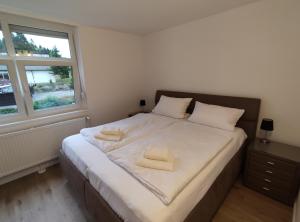 1 dormitorio con 1 cama con 2 toallas en 2-Zimmer Wohnung, Pools, Sauna und Balkon mit Südblick, en Sankt Englmar
