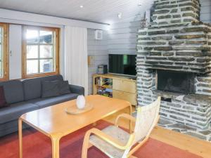 ein Wohnzimmer mit einem Tisch und einem Steinkamin in der Unterkunft Holiday Home Alkuvilla by Interhome in Saariselkä