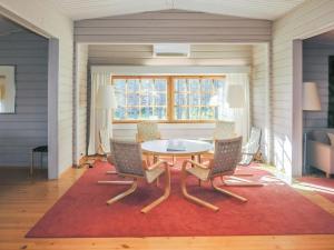 ein Esszimmer mit einem Tisch und Stühlen auf einem roten Teppich in der Unterkunft Holiday Home Alkuvilla by Interhome in Saariselkä