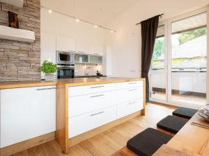 a kitchen with white cabinets and a stone wall at Apartment Christine Penthouse by Interhome in Eben im Pongau +11 photos