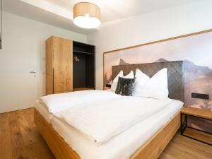 um quarto com uma grande cama branca e uma cabeceira em madeira em Apartment Christine Penthouse by Interhome em Eben im Pongau