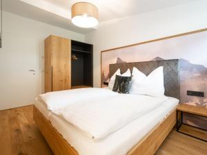 a bedroom with a large white bed with a wooden headboard at Apartment Christine Penthouse by Interhome in Eben im Pongau