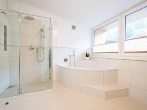 uma casa de banho com uma banheira e um chuveiro em vidro. em Apartment Christine Penthouse by Interhome em Eben im Pongau