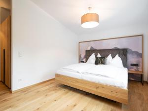 um quarto com uma cama branca e uma cabeceira em madeira em Apartment Christine Penthouse by Interhome em Eben im Pongau